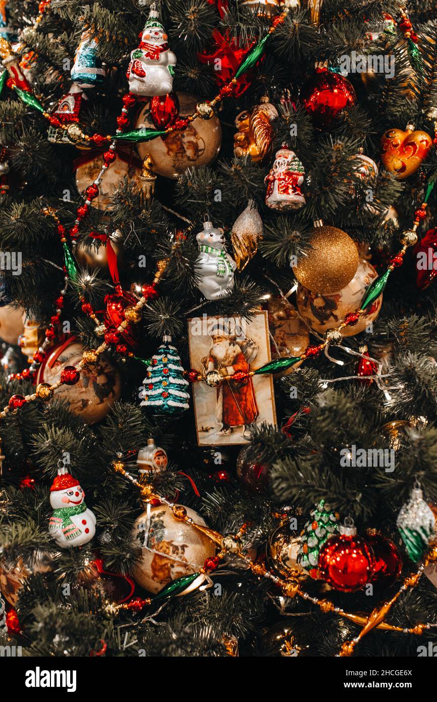 Grüne Zweige mit Weihnachtsbaum, verziert mit Vintage-Spielzeug und bunten Retro-Perlen. Neujahr Wintersaison. Weihnachts-Postkarte mit Glitzer-Bokeh-Licht Stockfoto