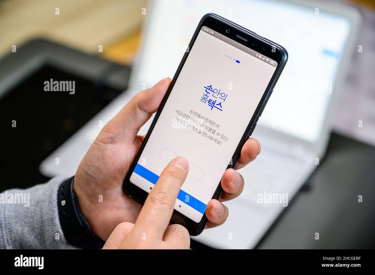 Seoul, Südkorea - 29. Dezember 2021: Die Hand eines Mannes, der eine Smartphone-App für die Steueranpassung am Jahresende installiert. Stockfoto