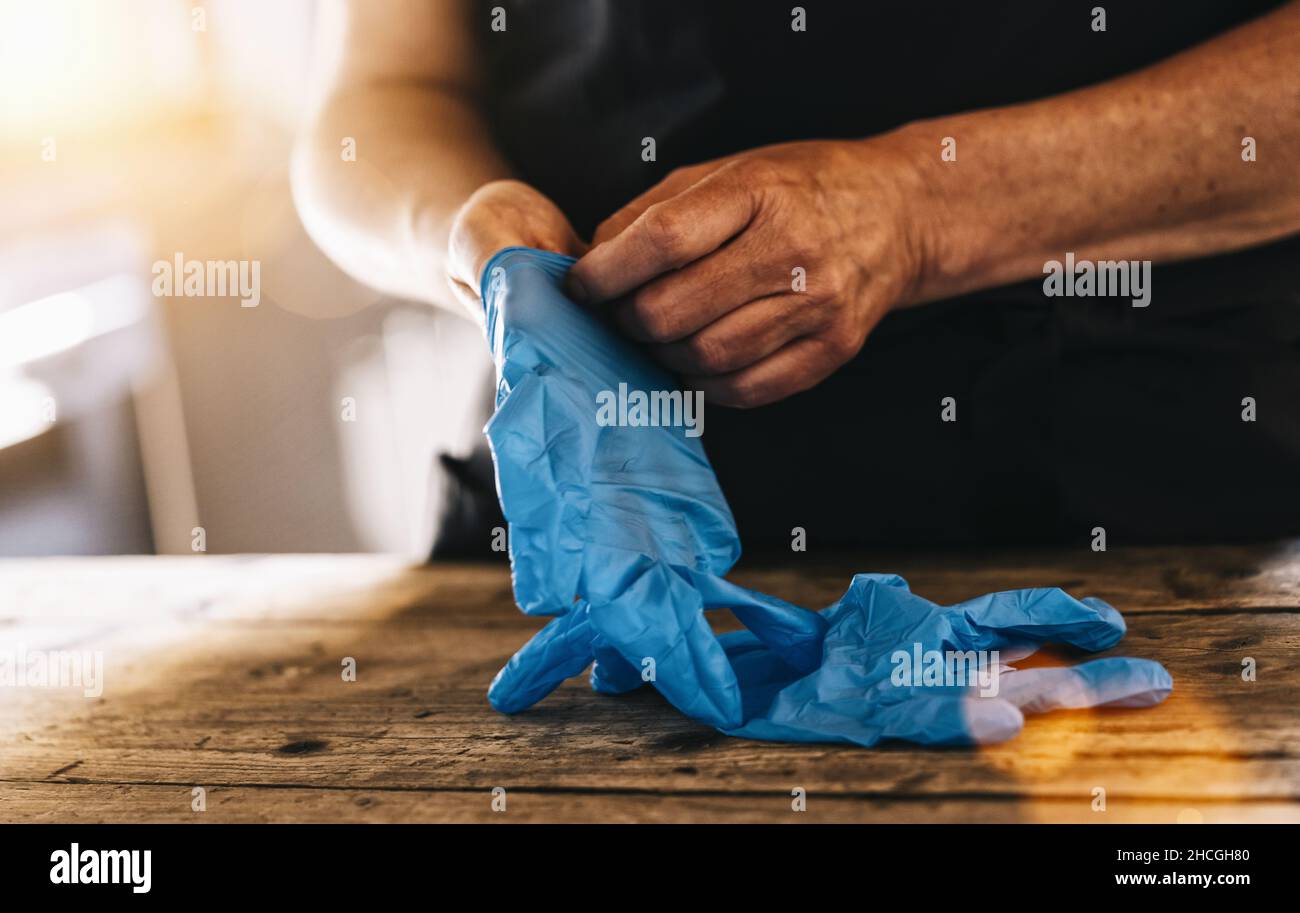 Barkeeper oder Mitarbeiter, der bei der Arbeit medizinische Latexhandschuhe trägt, um Corona COVID-19- und SARS-Infektionen zu verhindern Stockfoto