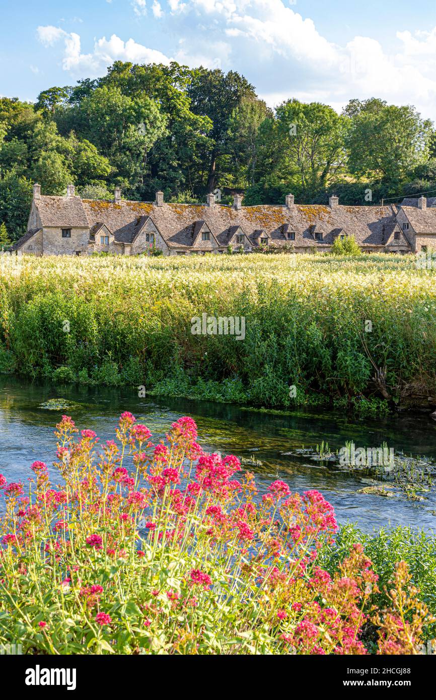 Abends fällt Licht auf die Arlington Row, Weberhütten aus dem späten 14th. Jahrhundert neben dem River Coln im Cotswold-Dorf Bibury, Gloucestershire, Großbritannien Stockfoto
