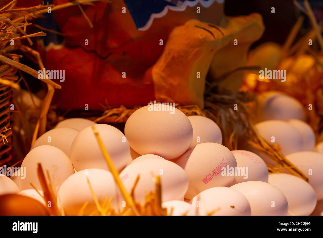 Nahaufnahme von Bio-Hühnereiern in einem Strohkorb auf dem spanischen Markt von Boqueria Stockfoto