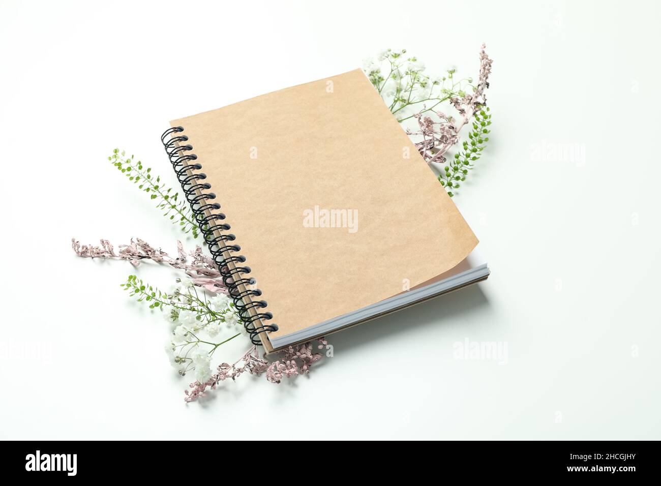 Leeres Notizbuch mit Blumen auf weißem Hintergrund Stockfoto