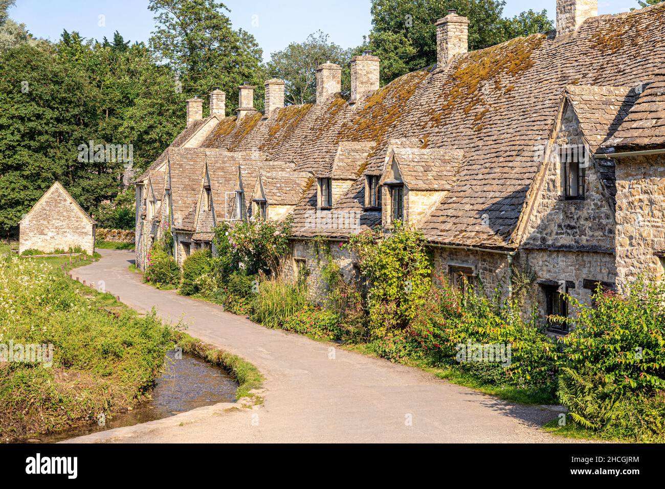 Abendlicht fällt auf die Arlington Row, Weberhütten aus dem späten 14th. Jahrhundert im Cotswold-Dorf Bibury, Gloucestershire, Großbritannien Stockfoto