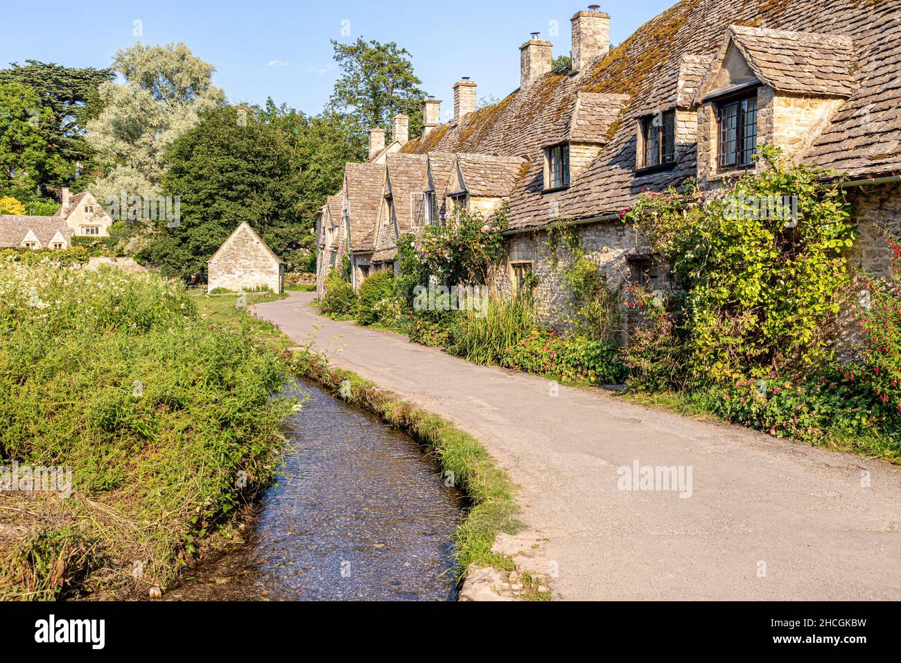 Abendlicht fällt auf die Arlington Row, Weberhütten aus dem späten 14th. Jahrhundert im Cotswold-Dorf Bibury, Gloucestershire, Großbritannien Stockfoto