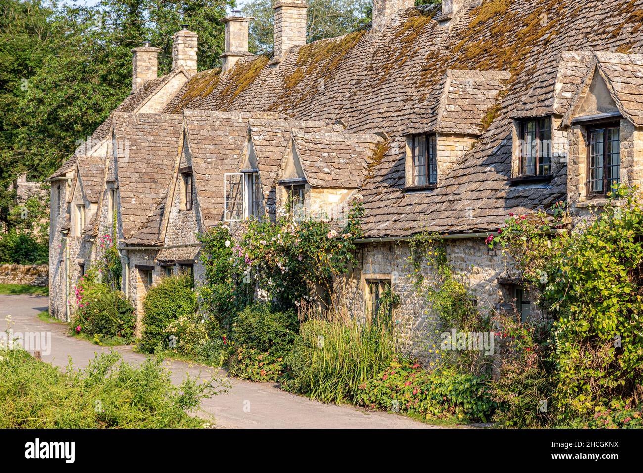 Abendlicht fällt auf die Arlington Row, Weberhütten aus dem späten 14th. Jahrhundert im Cotswold-Dorf Bibury, Gloucestershire, Großbritannien Stockfoto