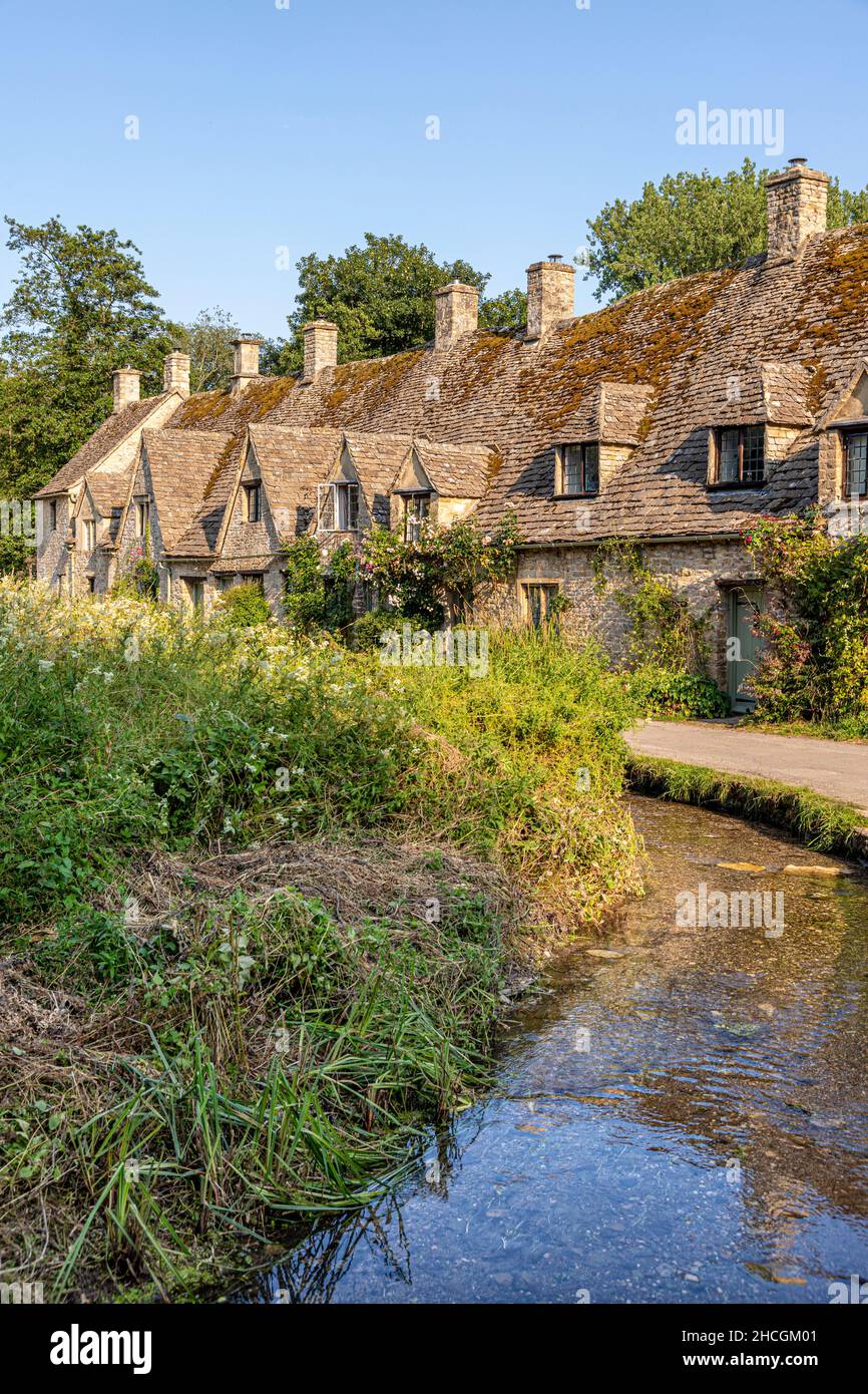 Abendlicht fällt auf die Arlington Row, Weberhütten aus dem späten 14th. Jahrhundert im Cotswold-Dorf Bibury, Gloucestershire, Großbritannien Stockfoto