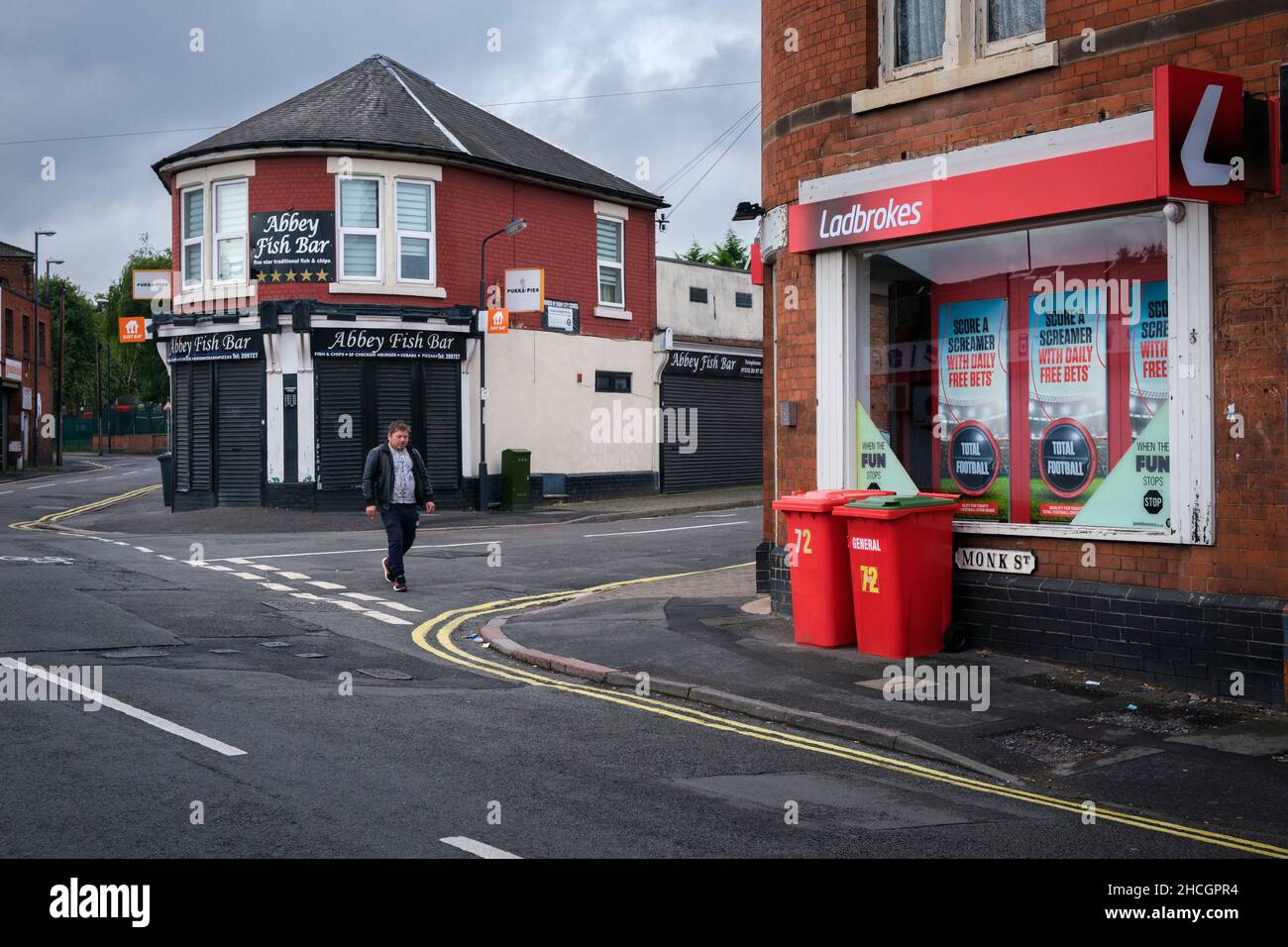 Eine Straßenszene in einer Innenstadt von Derby mit einem Fisch- und Chipshop und einem Wettshop an den Straßenecken, Derby, England Stockfoto