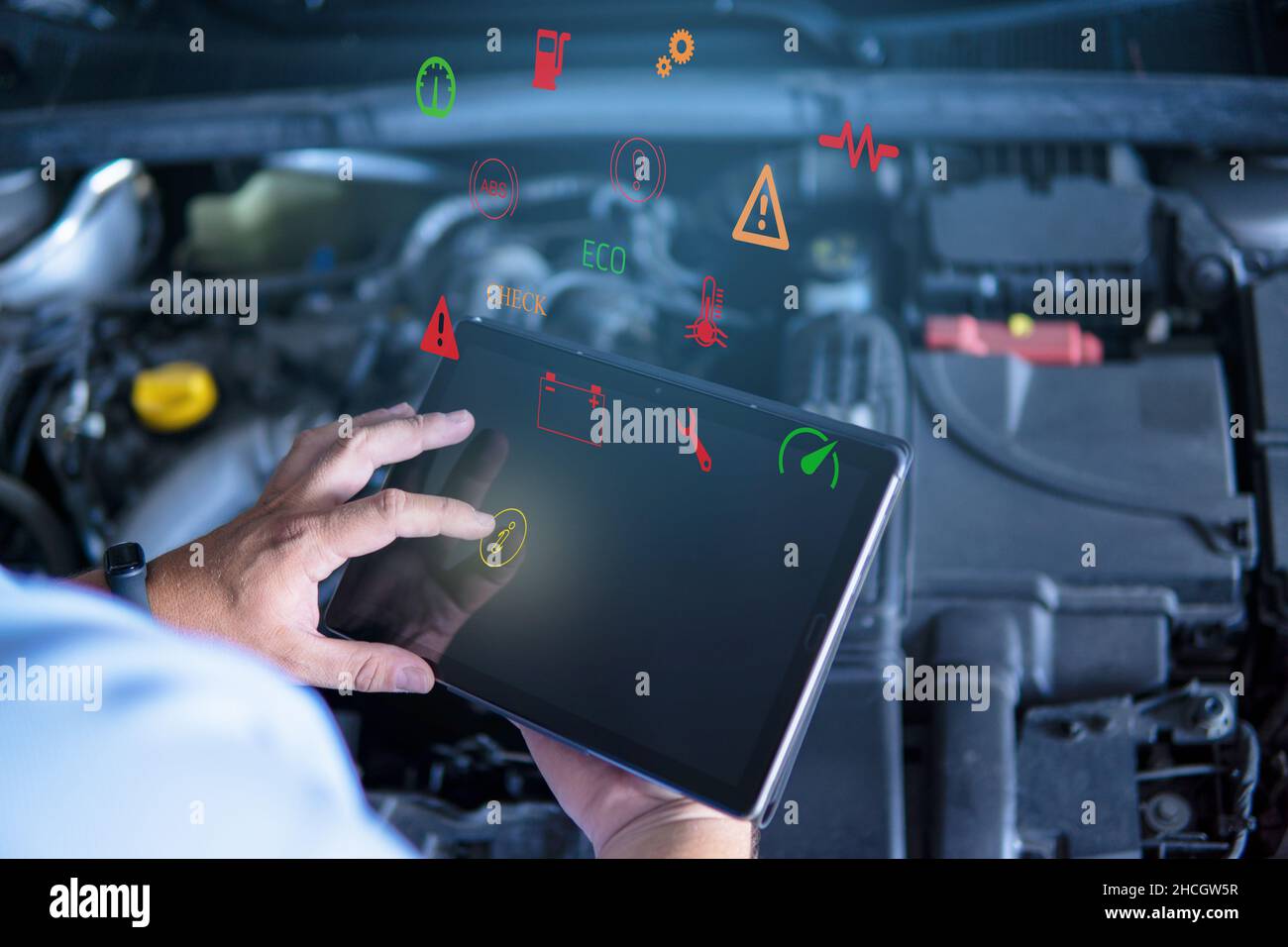 Automechaniker mit digitalem Tablet bei der Arbeit, der eine Motorreparaturdiagnose eines Autos in einer Mechaniker-Garage erstellt und Symbole auf dem virtuellen Bildschirm berührt Stockfoto