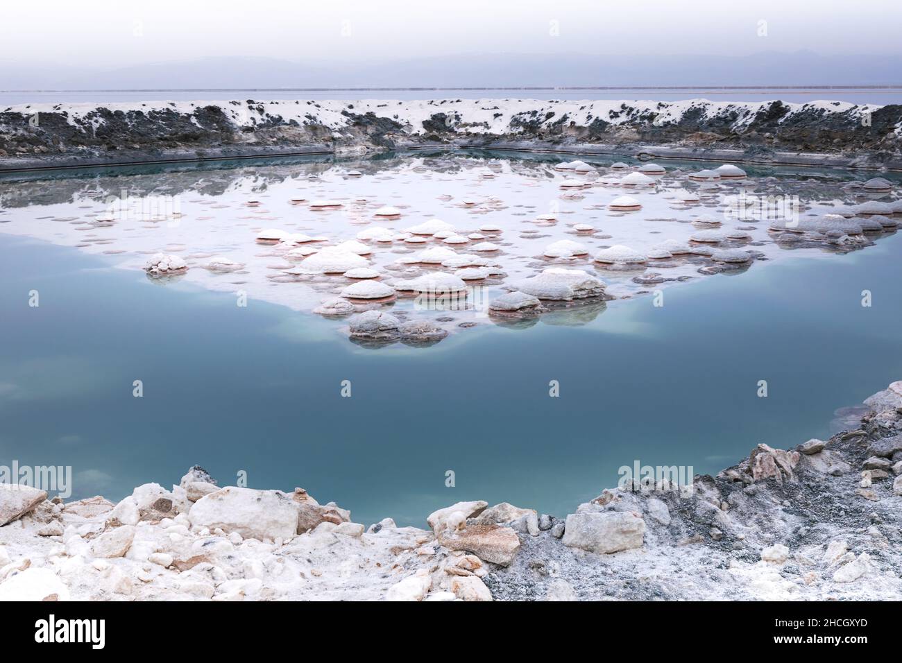Schönes und farbenfrohes natürliches Salzreservoir nach Regen während des bewölkten Herbsttages am Tuzsee in zentralanatolien, Türkei. Stockfoto