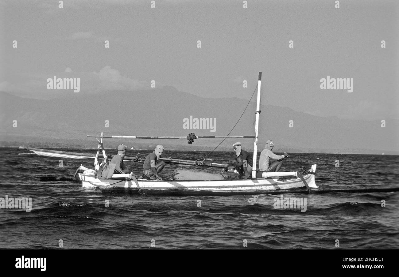 Muscheltaucher mit Masken, die vor den Sonnenstrahlen geschützt sind, auf einem Holzboot, Bali, Indonesien Stockfoto