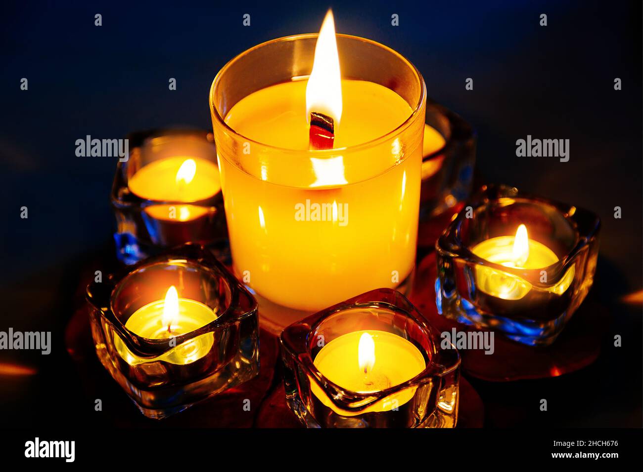Gedächtniskerzen brennen im Dunkeln. Trauerritual und Trauer um Tote. Kerzen in Kerzenleuchtern aus nächster Nähe. Hintergrund Stockfoto