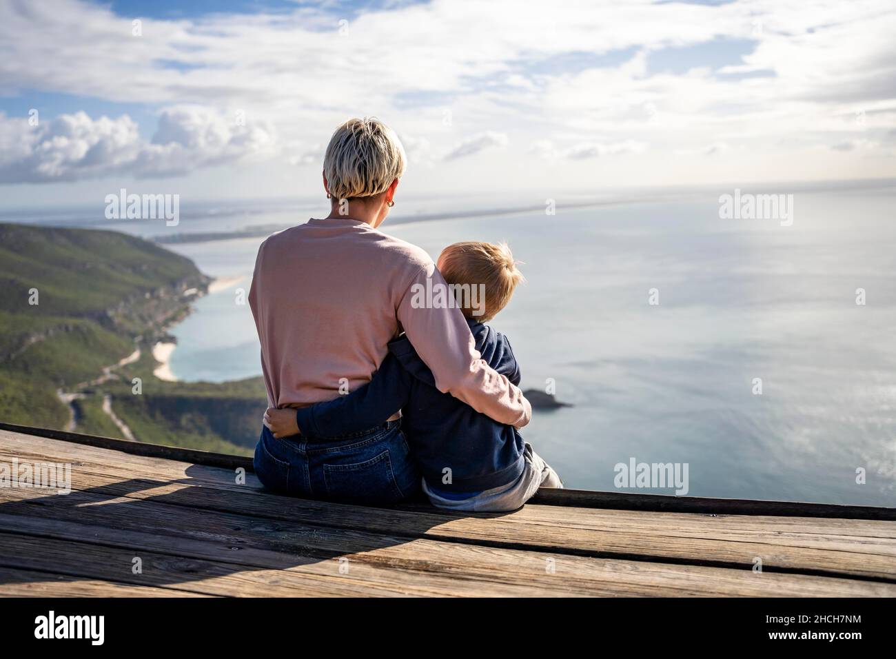 Mutter und 3 Jahre alter Sohn umarmen sich gegenseitig und genießen die wunderschöne Aussicht auf das Meer, Portugal Stockfoto