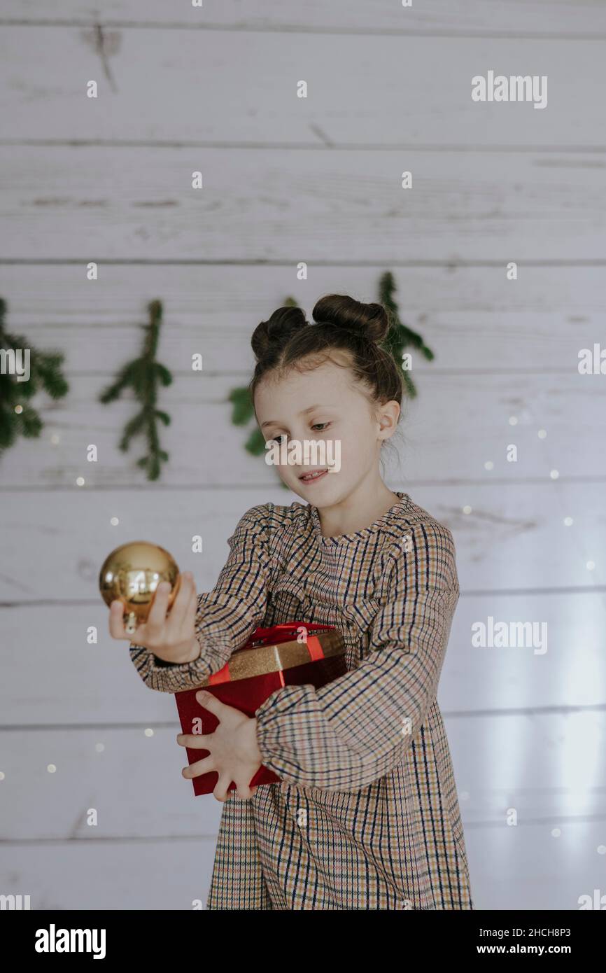 Mädchen mit Weihnachtsgeschenk vor einer weihnachtlichen Kulisse Stockfoto