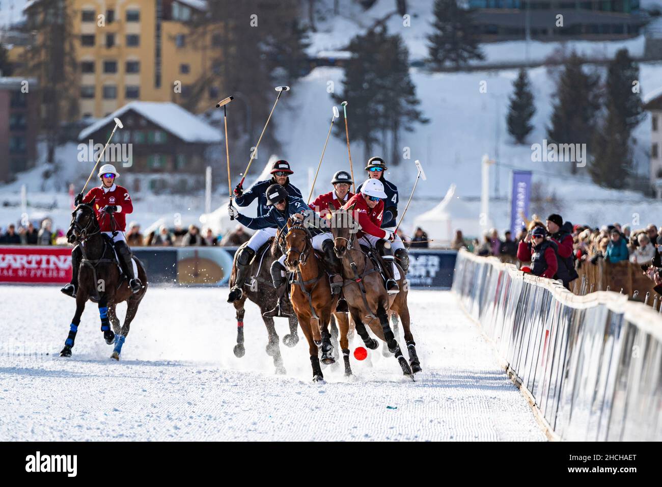 Spieler vom Team Maserati (blau) und Spieler vom Team St. Moritz (rot) kämpfen mit voller körperlicher Anstrengung auf der Schiene um den Ball, 36th Snow Polo Stockfoto