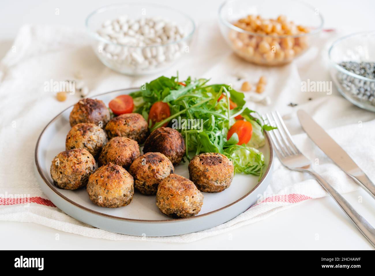 Vegane vegetarische Fleischbällchen auf dem Teller mit frischem Salat. Pflanzlichen Erbsenproteinbestandteile auf dem Hintergrund. Vegetarisches Mittagessen. Gesunde Ernährung Konzept. Stockfoto