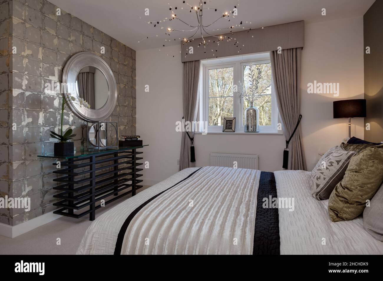 Kentford, Suffolk, England - Feb 25 2016: Modernes, nagelneues Zuhause mit moderner Schlafzimmereinrichtung inklusive Doppelbett, Sidetable mit Spiegel abov Stockfoto