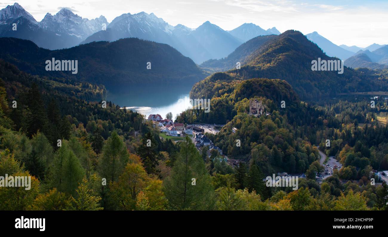 Blick vom berühmten Schloss Neuschwanstein im Herbst mit wechselnden Blättern und Blick auf das historische Dorf und Schloss Hohenschwangau Stockfoto