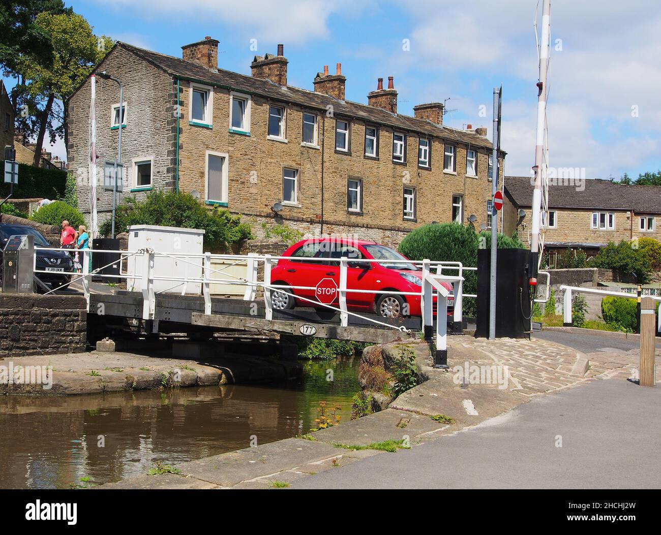 Schwingt eine Brücke mit einem roten Auto, das den Thanet Canal oder den Spring Branch des Leeds und Liverpool Canal von Skipton nach Skipton Castle überquert. Stockfoto