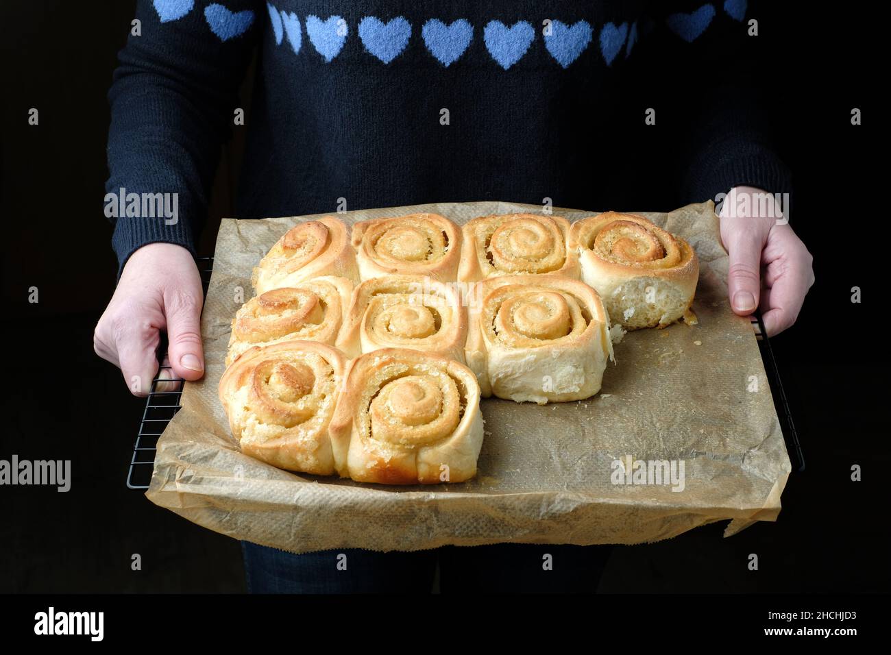 Ein Tablett mit frisch gebackenen, hausgemachten, zitronengewirbelten Chelsea-Brötchen. Die Brötchen sind immer noch wie gebacken und nicht auf Backpapier getrennt Stockfoto