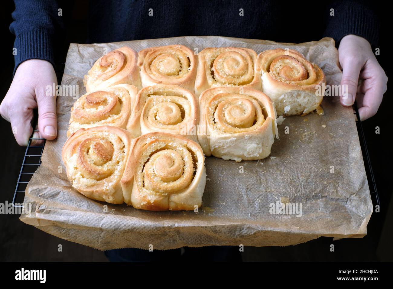 Ein Tablett mit frisch gebackenen, hausgemachten, zitronengewirbelten Chelsea-Brötchen. Die Brötchen sind immer noch wie gebacken und nicht auf Backpapier getrennt Stockfoto