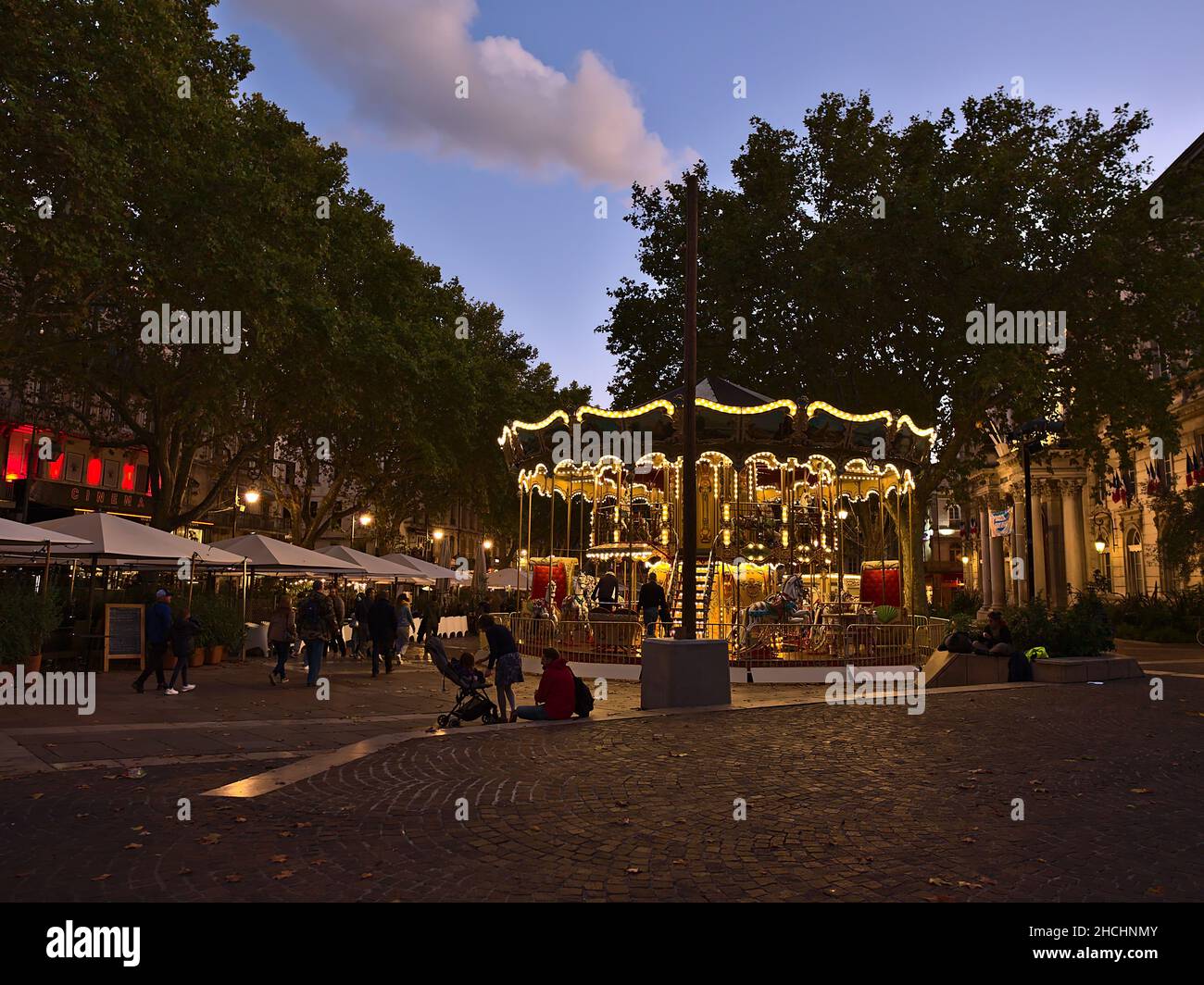 Schöner Blick auf den belebten Platz Place de l'Horloge im historischen Zentrum von Avignon, Provence, Frankreich am Abend mit Karussell. Stockfoto