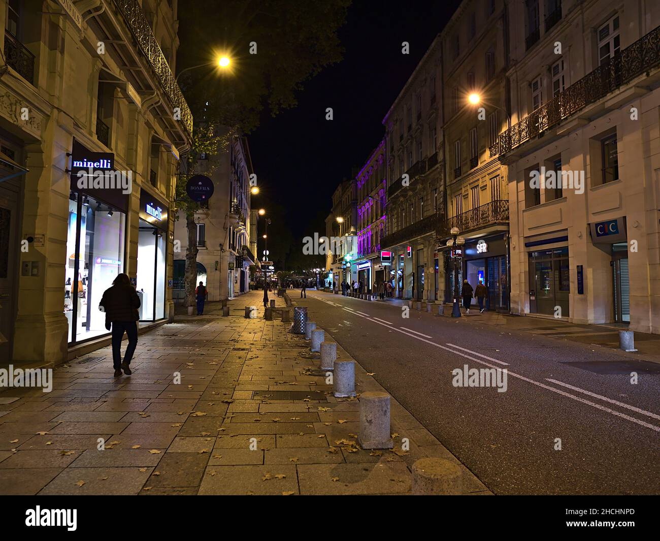 Nachtansicht der Rue de la Republique im historischen Zentrum von Avignon, Provence, Frankreich mit beleuchteten Gebäuden, Geschäften und Spaziergängen. Stockfoto
