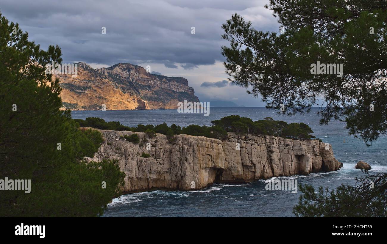 Blick auf die schroffen Klippen des Massif des Calanques in der Nähe von Cassis, an der französischen Riviera an der mittelmeerküste mit Bäumen und Cap Canaille. Stockfoto
