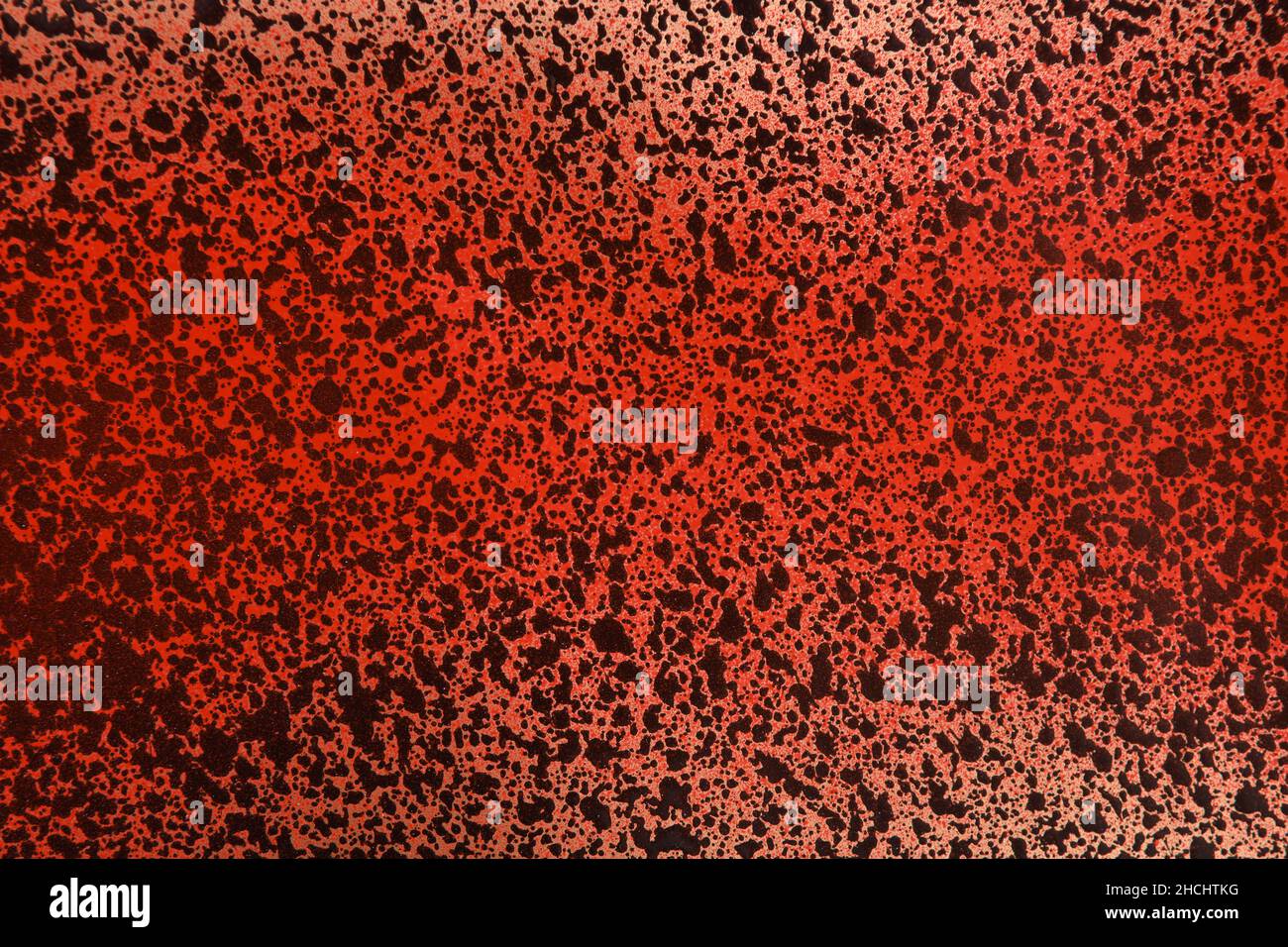 Schwarze und rote Sprühfarbe auf goldfarbenem Papier Stockfoto