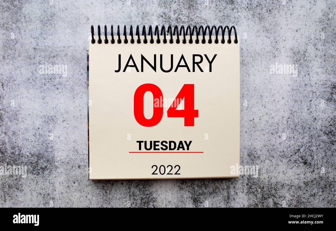 Januar 4 auf weißem Notizpad.Neben ihm ist eine blaue Uhr auf rotem Hintergrund.Kalender für Januar Stockfoto