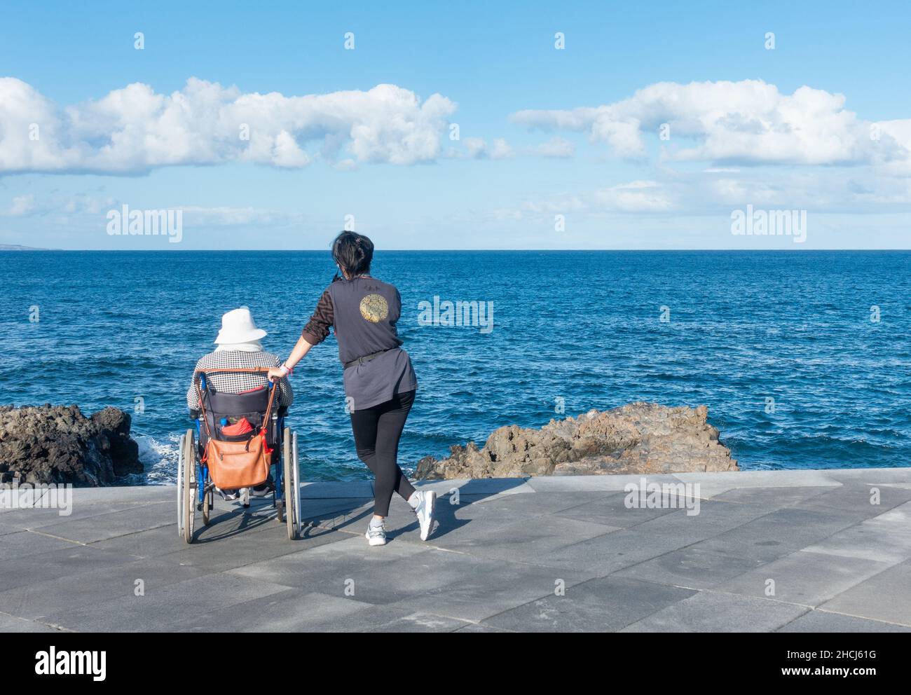 Ältere Person aus dem Pflegeheim auf einem Tagesausflug zum Strand in Spanien Stockfoto