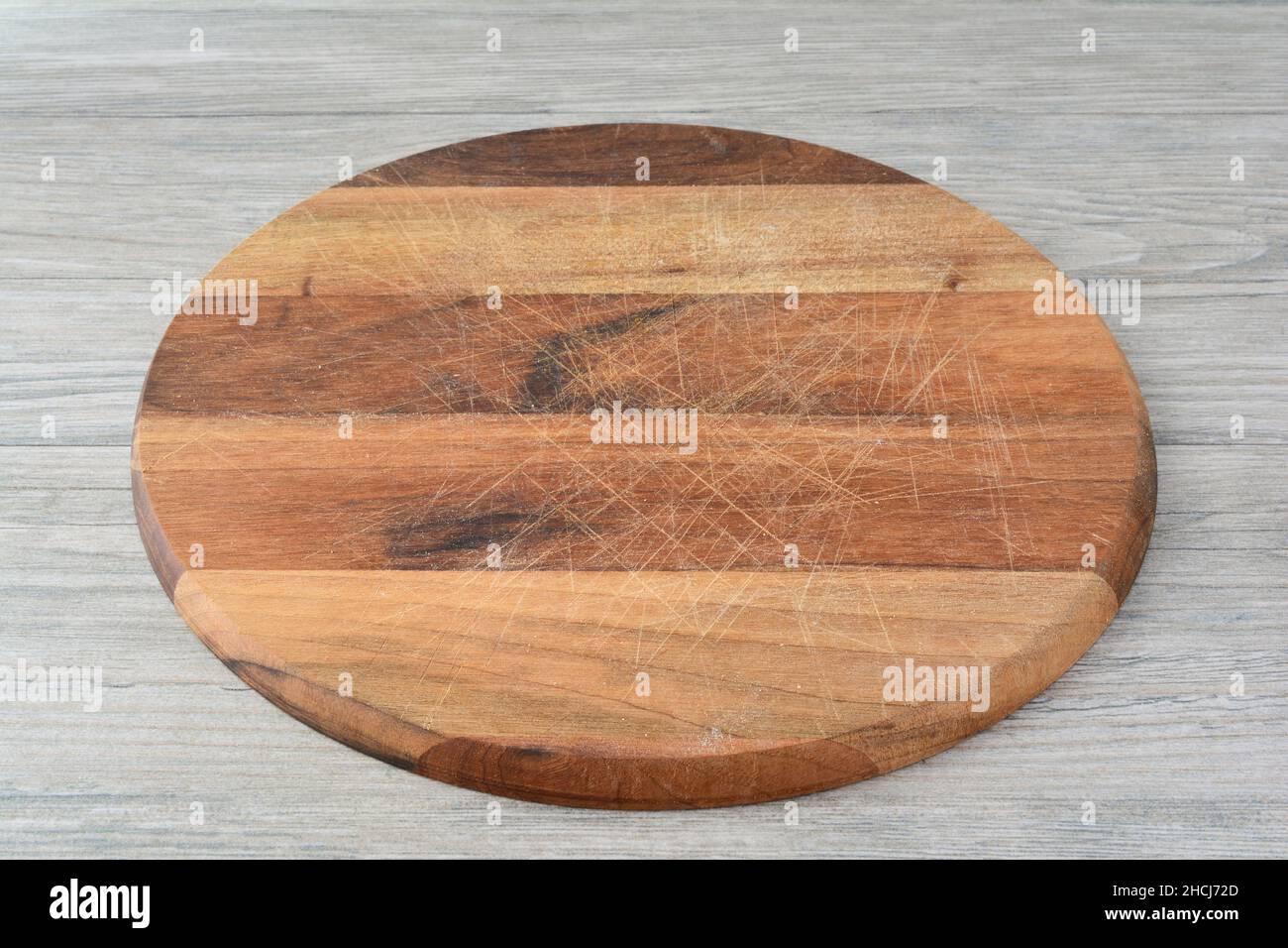 Blanke runde dunkle Holzhackbrett auf grauem Holzhintergrund, Draufsicht, Kopierraum Stockfoto
