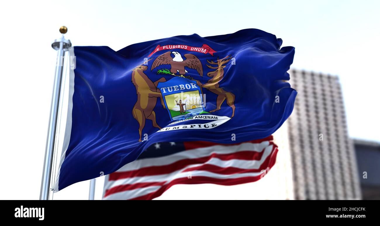 Die Flagge des US-Bundesstaates Michigan winkt im Wind, die amerikanische Flagge verschwimmt im Hintergrund. Michigan wurde am Januar in die Union aufgenommen Stockfoto