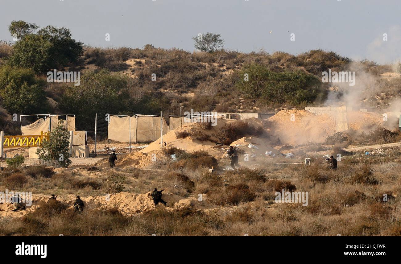 Kämpfer bewaffneter palästinensischer Gruppierungen aus dem Gazastreifen nehmen am Mittwoch, dem 29. Dezember 2021, an einer Militärübung Teil und simulieren einen Angriff auf einen israelischen Panzer an einem Ort in Rafah im südlichen Gazastreifen. Israel beschuss mutmaßliche Hamas Militärstandorte in Gaza am Mittwoch, nachdem ein israelischer Zivilist durch Schüsse aus der palästinensischen Enklave verletzt worden war, sagten Sicherheitsquellen in Gaza. Zwei palästinensische Bauern wurden durch das israelische Artillerieböll verletzt, das auf vier mutmaßliche Standorte abzielte, die vom militärischen Flügel der Hamas, den Al-Qassam Brigaden, benutzt wurden, berichteten Quellen der Presse. Foto von Ismael Mohamad/UPI. Stockfoto