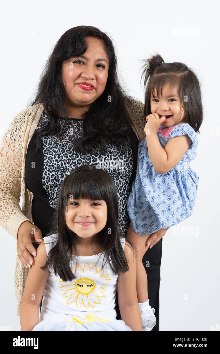 Nahaufnahme Porträt von 4 oder 5-jährigen Mädchen, lächelnd, weißen Hintergrund, mit ihrer Mutter und Kleinkind Schwester Stockfoto
