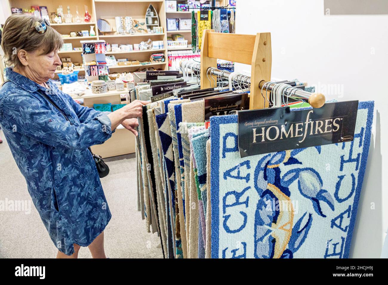 Vero Beach Florida Museum of Art VBMA Innen-Geschenkladen Senior Frau Einkaufen werfen Teppiche Stockfoto