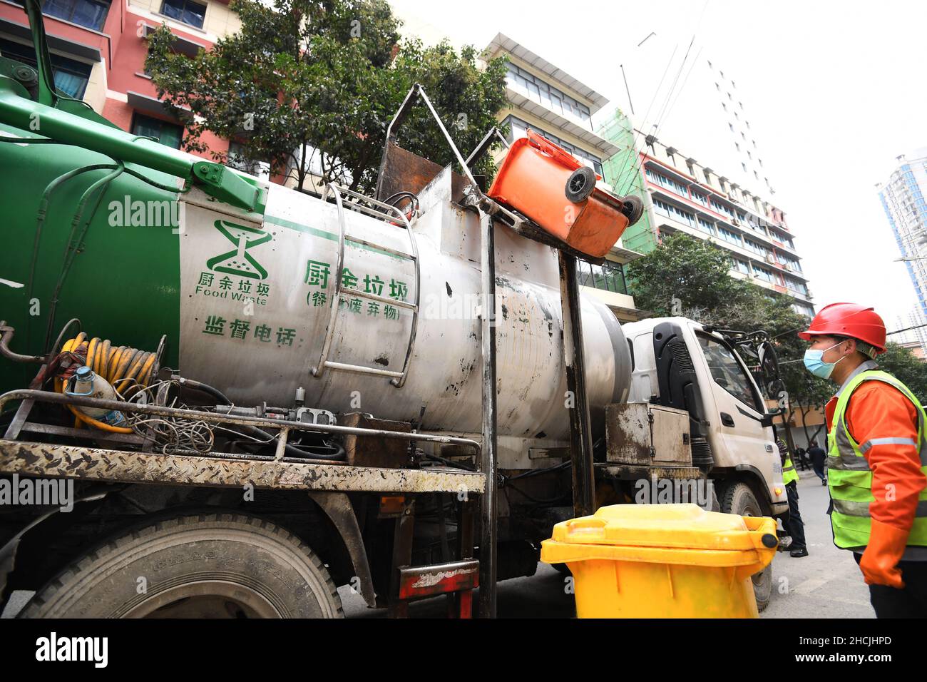 GUIYANG, CHINA - 29. DEZEMBER 2021 - Ein Mitarbeiter lädt Lebensmittelabfälle aus Restaurants in einen LKW zur Sammlung und zum Transport von Lebensmittelabfällen in Guiyang Stockfoto