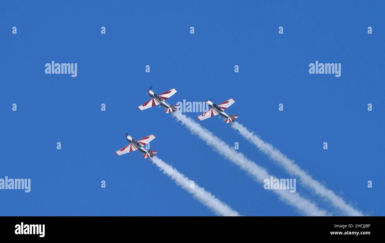 Thiene Italien 16. OKTOBER 2021 Gruppe von Flugzeugen am blauen Himmel mit Rauch und riesigen Kopieflächen. Yakovlev Yak-52 von YAK Italia Stockfoto