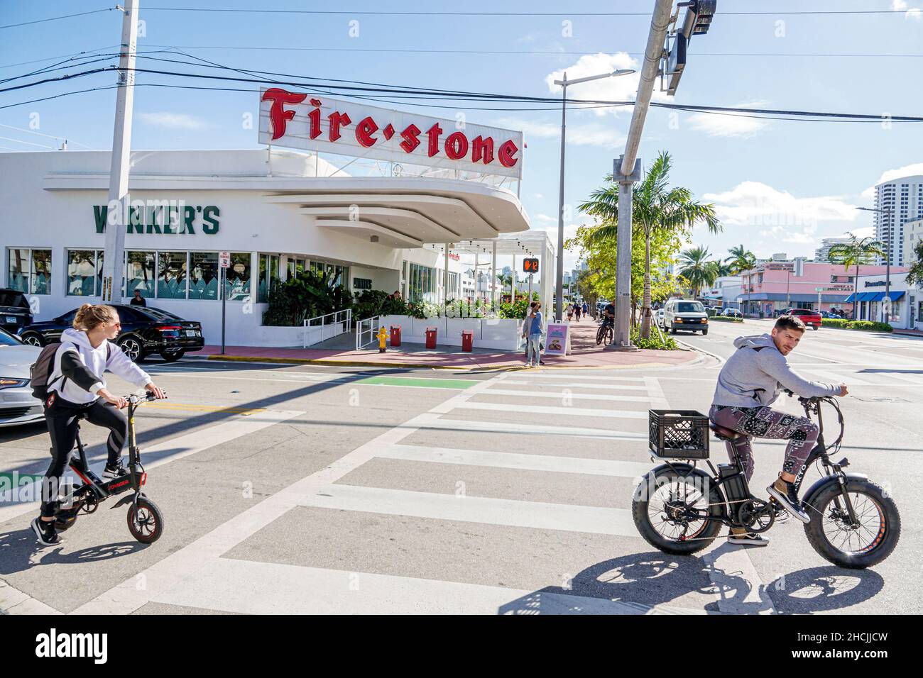 Miami Beach Florida Alton Road ehemalige Firestone Reifen Reifen Händler  riesigen Neon-Schild renoviert umgewandelten Restaurant  Elektro-Fahrrad-Fahrer Stockfotografie - Alamy