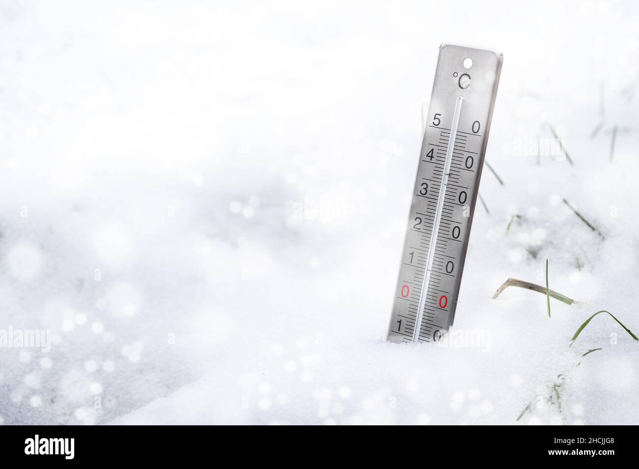 Thermometer im Schnee während eines kalten Winters, Konzept für Wetterphänomene, Klimawandel und steigende Heizkosten, Kopierraum, ausgewählter FOC Stockfoto