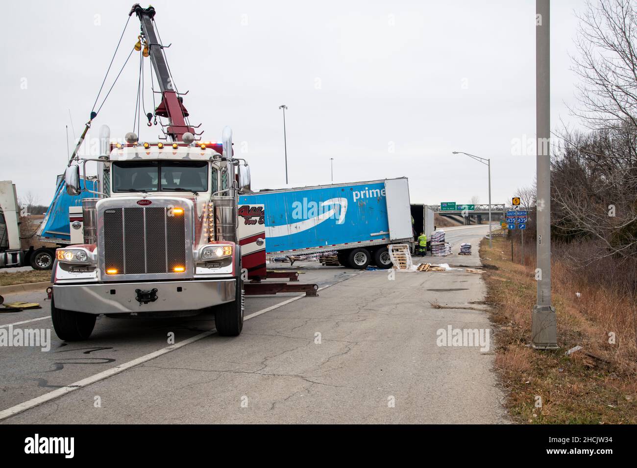 Kansas City, Kansas. LKW, der Amazon Prime Anhänger voller Hundefutter zog,  kam zu schnell von der Autobahnrampe und drehte sich auf der Straße um.  Abschleppwagen mit Stockfotografie - Alamy