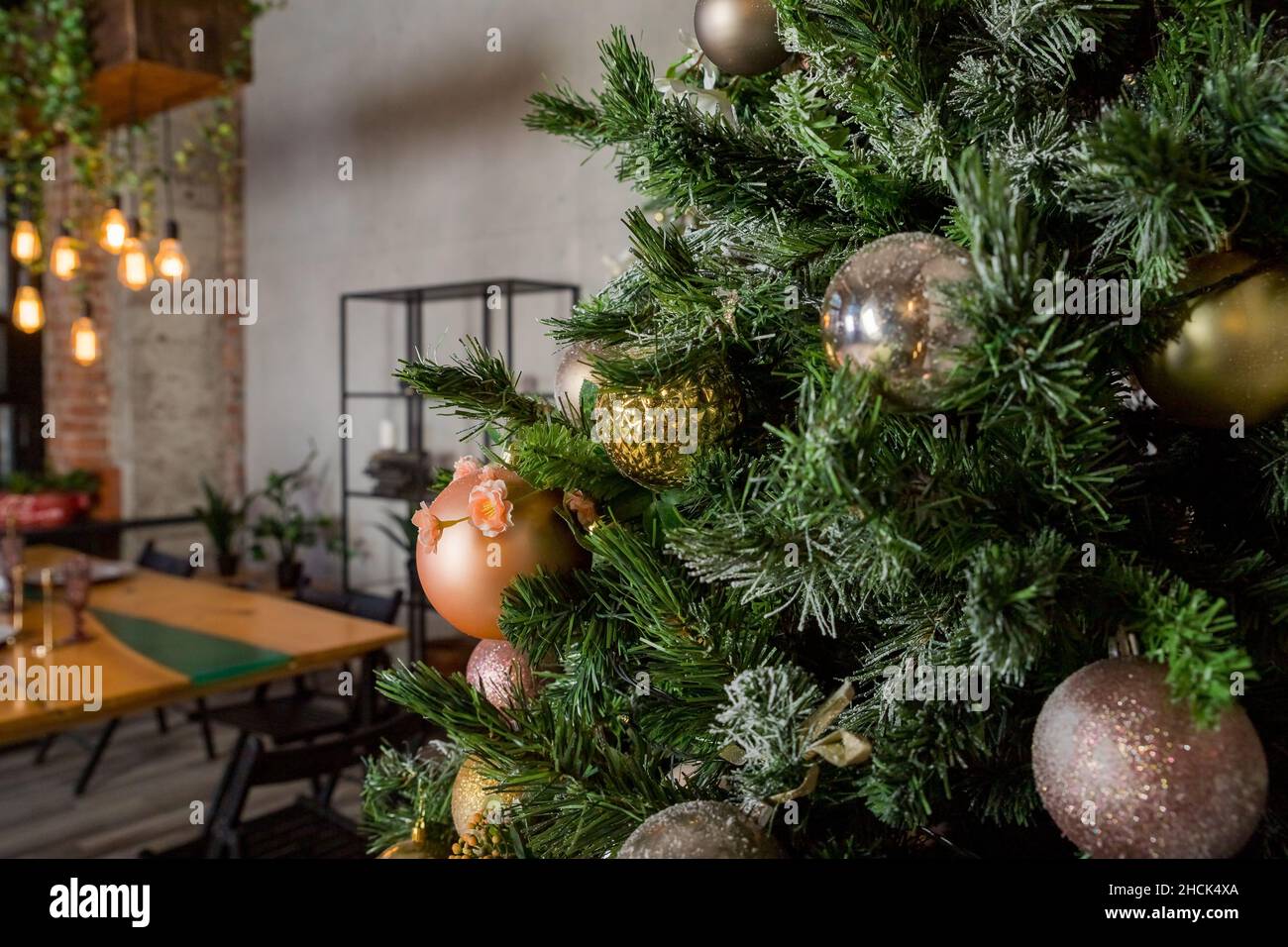 Luxuriöser Weihnachtsbaum mit weißen, silbernen und rosa Kugeln, Schnee und leuchtender Girlande. Stockfoto
