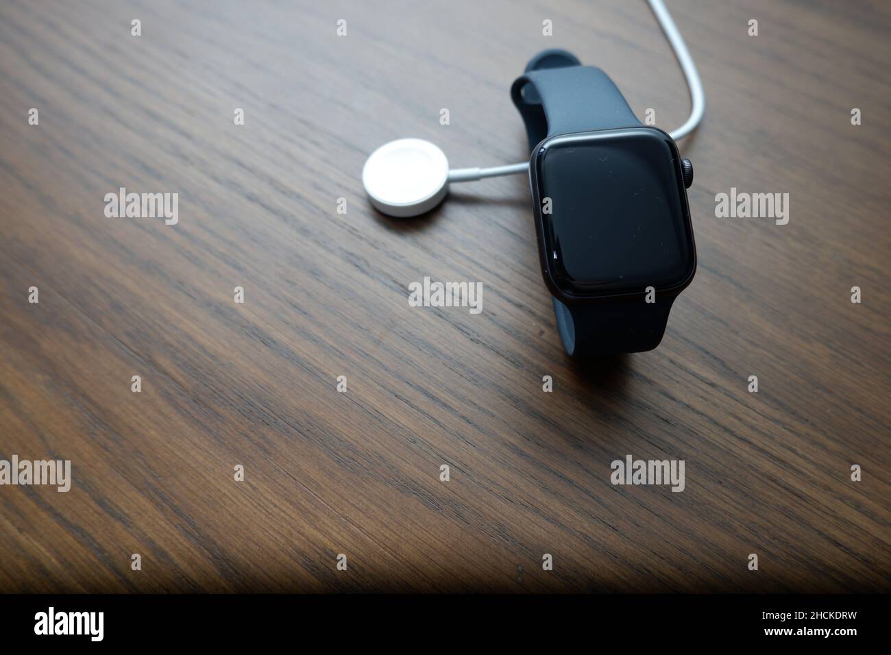 Hongkong - 30. Dez 2021: Apple Watch und Ladegerät auf Holzhintergrund mit Kopierraum Stockfoto