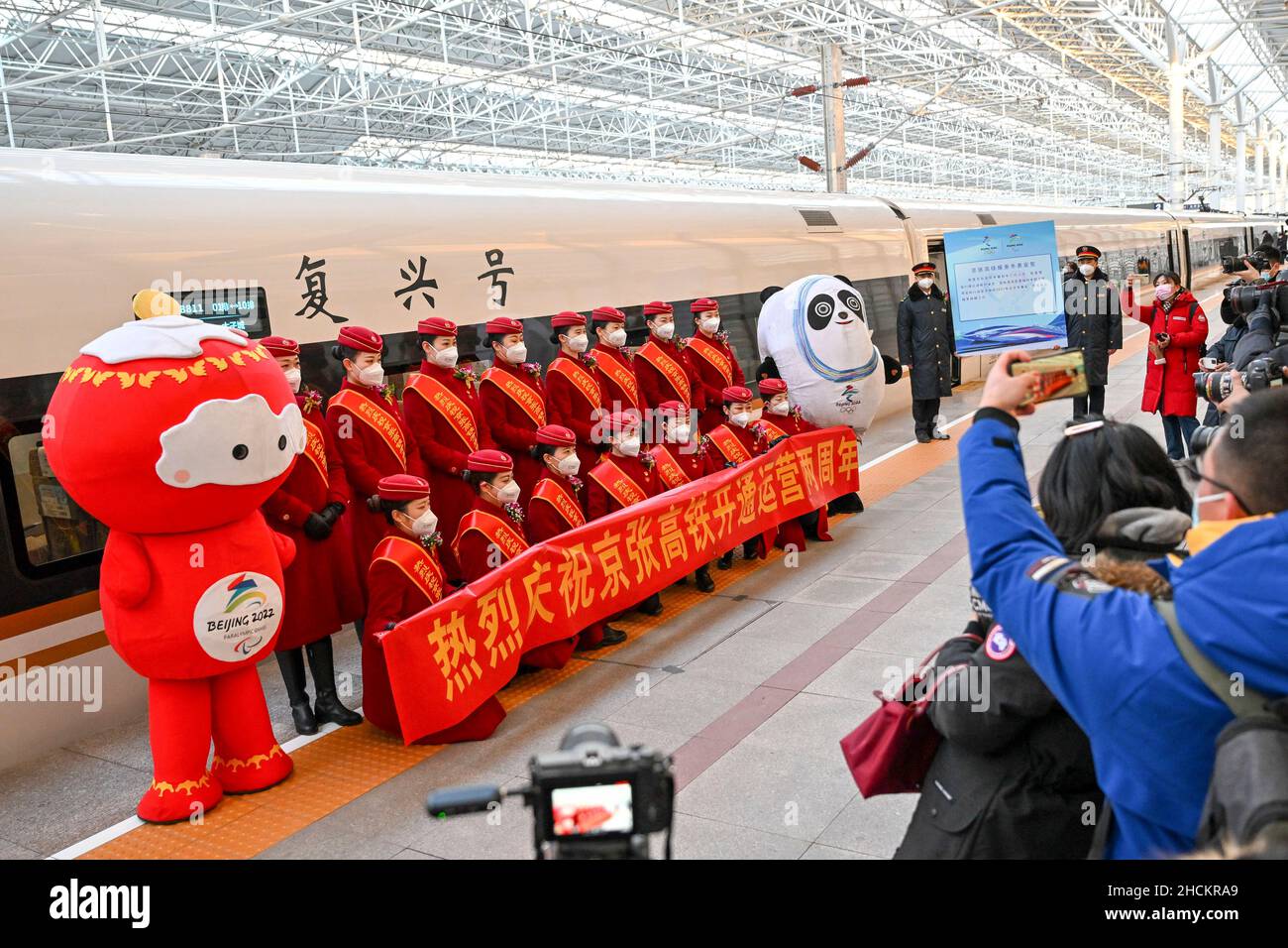 (211230) -- PEKING, 30. Dezember 2021 (Xinhua) -- Reporter fotografieren während einer Veranstaltung zum zweijährigen Jubiläum der Eröffnung der Hochgeschwindigkeitsstrecke Peking-Zhangjiakou am Nordbahnhof von Peking in Peking, der Hauptstadt Chinas, am 30. Dezember 2021. Die Hochgeschwindigkeitsbahn, die Peking und Zhangjiakou in der nordchinesischen Provinz Hebei verbindet, wurde am 30. Dezember 2019 in Betrieb genommen. (Foto von Fang Xin/Xinhua) Stockfoto