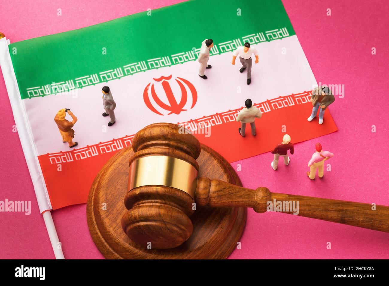 Richter Gavel, iranische Flagge und Kunststoff-Spielzeugmänner auf farbigem Hintergrund, das Konzept des Prozesses in der iranischen Gesellschaft, Draufsicht Stockfoto
