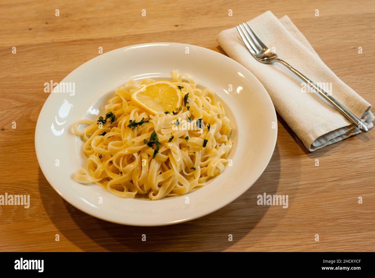 Italienische Zitronenpasta oder Tagliatelle al Limone auf einem weißen Teller mit Petersilie Stockfoto