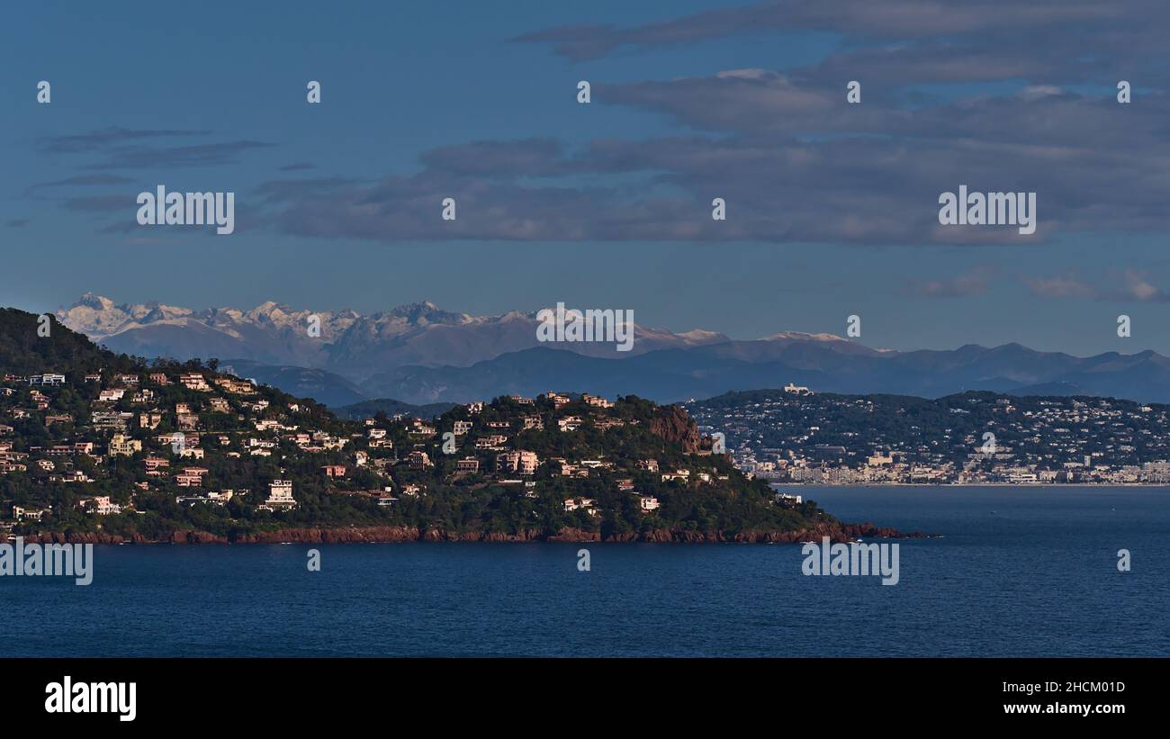 Atemberaubender Panoramablick auf die felsige mittelmeerküste vom Cap Roux in der Nähe von Saint-Raphael, Französische Riviera, Frankreich mit schneebedeckten Bergen. Stockfoto