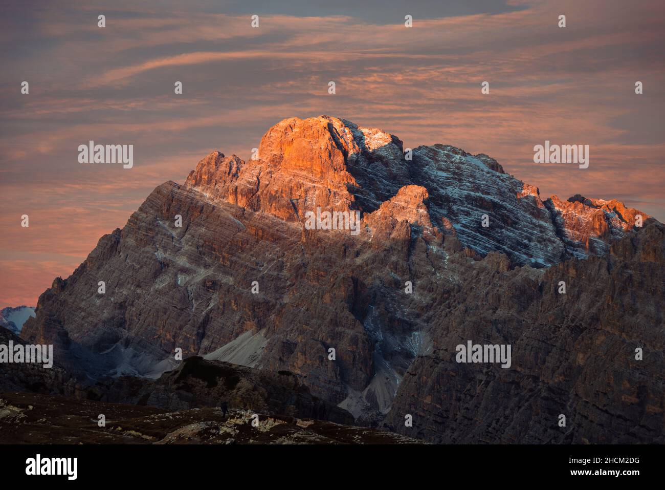 Der Gipfel und die Felsvorsprünge des Monte Cristallo in den Dolomiten leuchten bei Sonnenaufgang, Belluno, Italien, golden Stockfoto