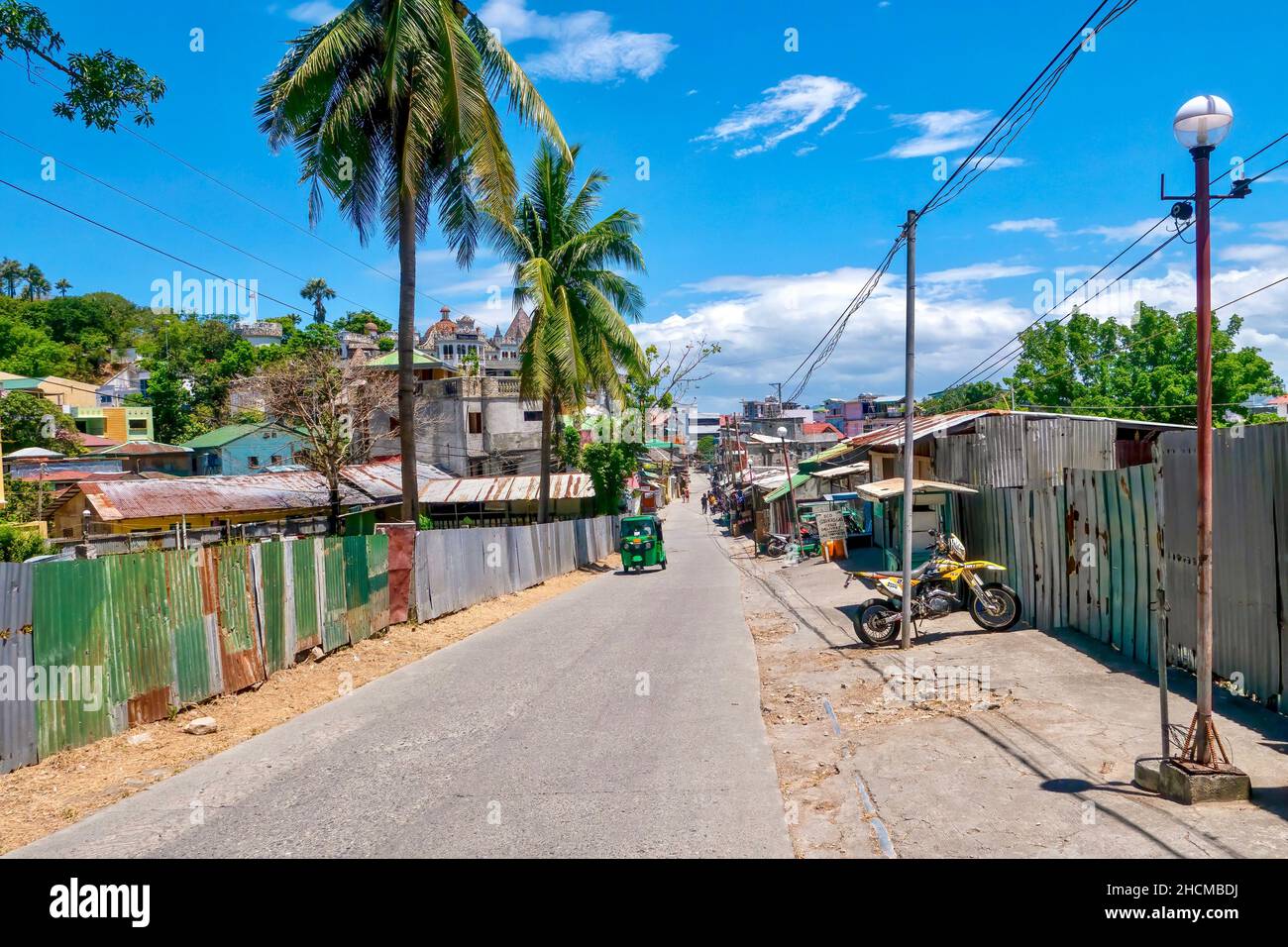 Sabang Village, Puerto Galera, Philippinen - 4. Mai 2021: Eine schmale Straße, gesäumt mit Wellblechplatten und einfachen Gebäuden. Stockfoto