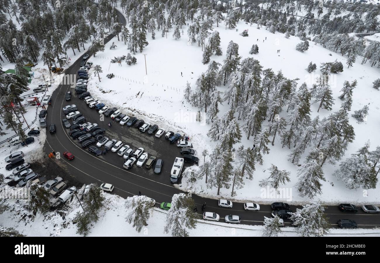 Drohnenantenne eines Parkplatzes auf dem verschneiten Waldberg im Winter. Wintersaison Stockfoto