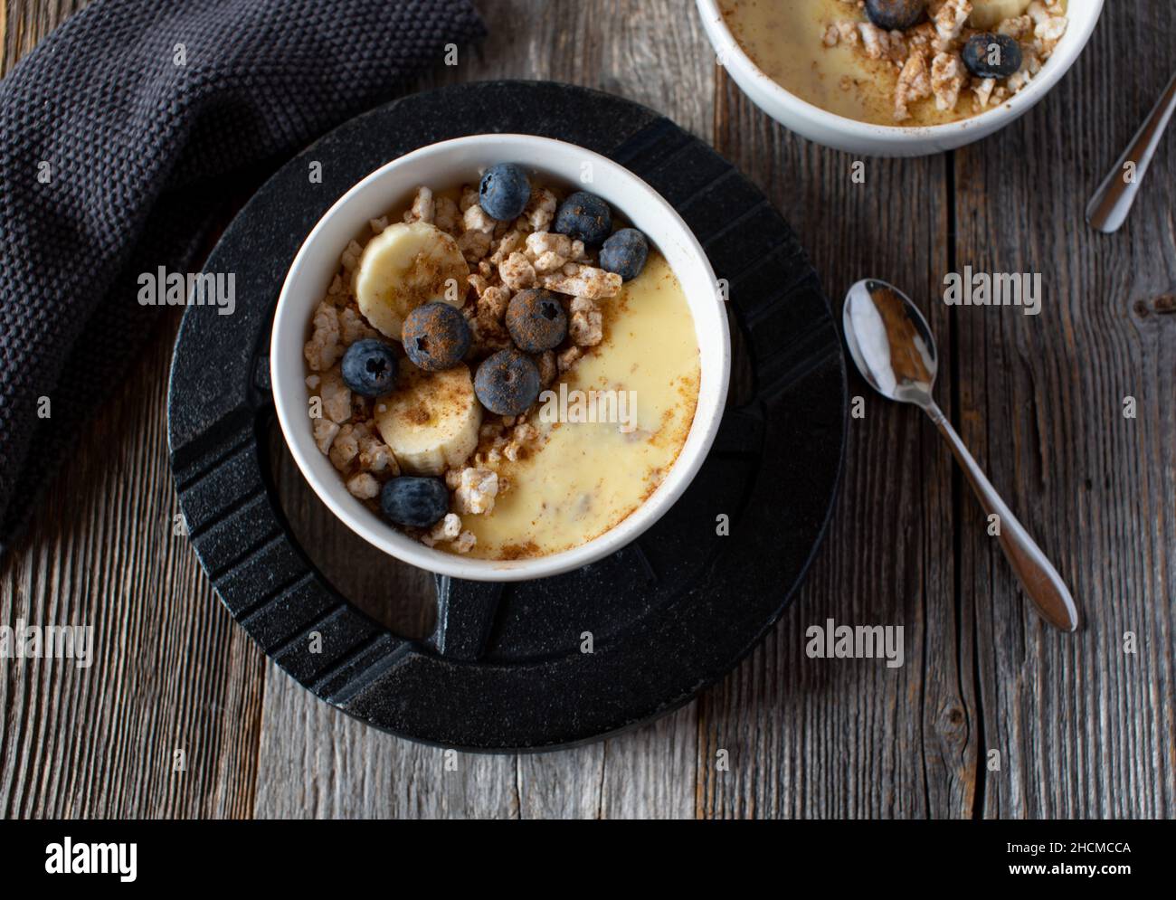 Fitness-Frühstückschale mit proteinreichem Vanillepudding. Serviert mit frischem Obst und braunem Reiskracker auf einer Hantelscheibe Stockfoto